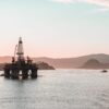 Scenic view of oil rigs at sunset