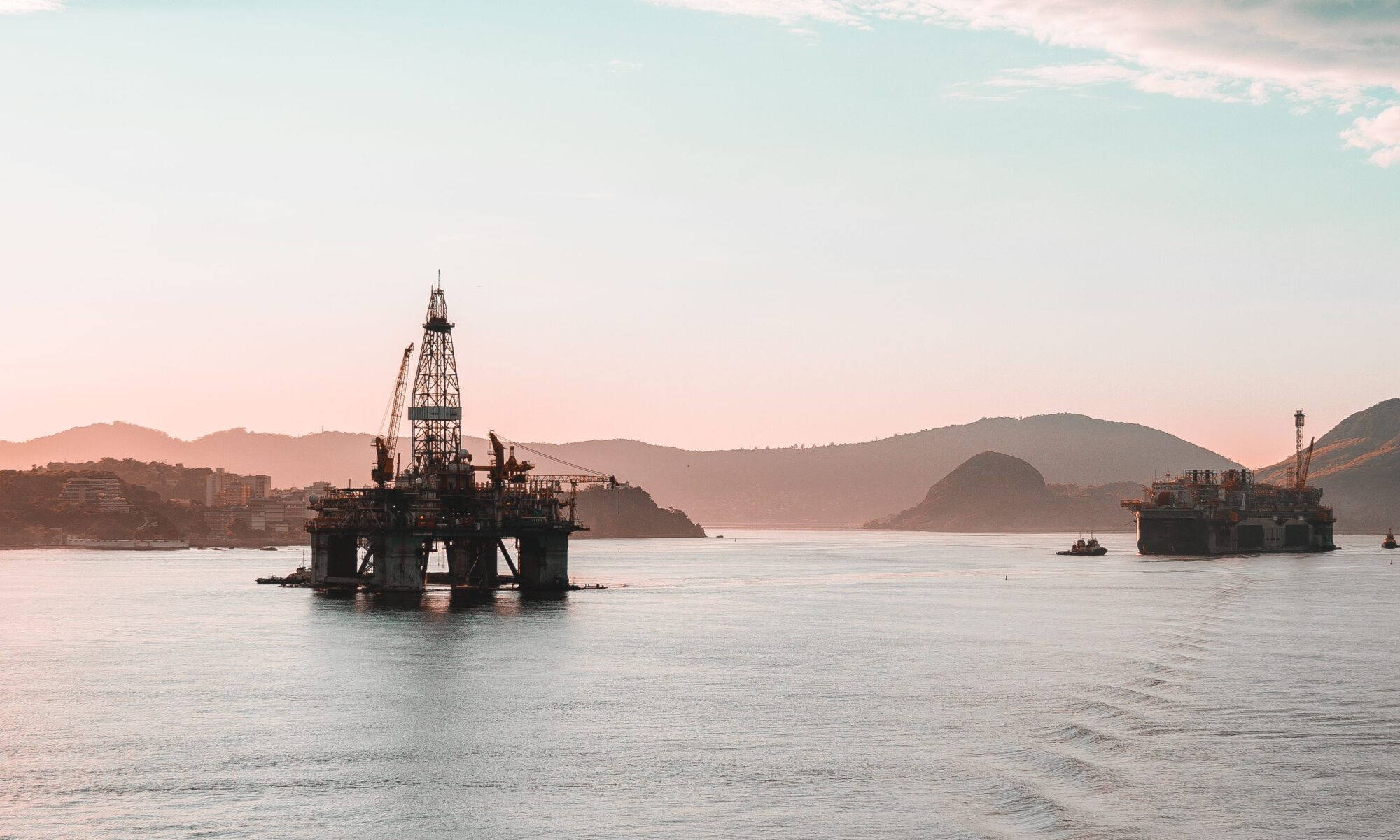 Scenic view of oil rigs at sunset