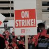 A sign reading "On Strike" is held by a participant during a strike. Photo: Spencer Pauley / The Center Square