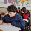 A group of children taking a test with focus and concentration in a classroom setting.